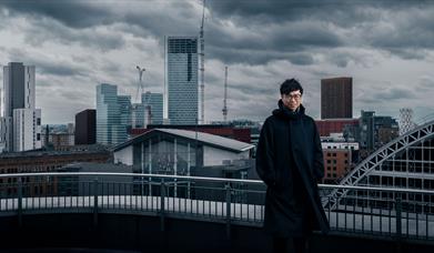 Man standing by Manchester's skyline