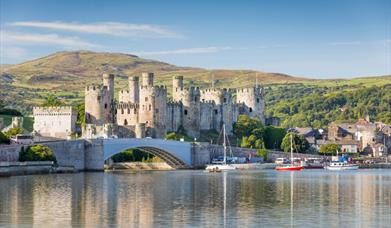 Conwy Castle with body of water and hills in the background