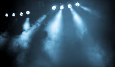 Image of a stage with spotlights shining
