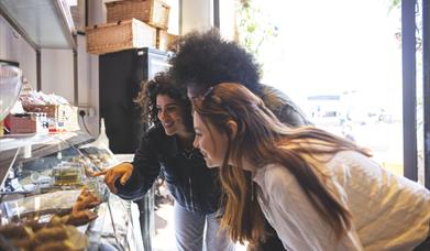 Friends looking in display cabinet with food at Salvi's Mozzarella Bar and Restaurant