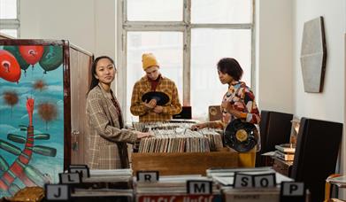 A Group of People Looking at Vintage Vinyl Records
