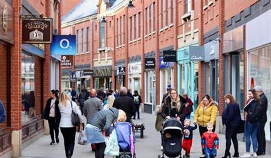 Shoppers walking along high street in Prince Bishop's Palace